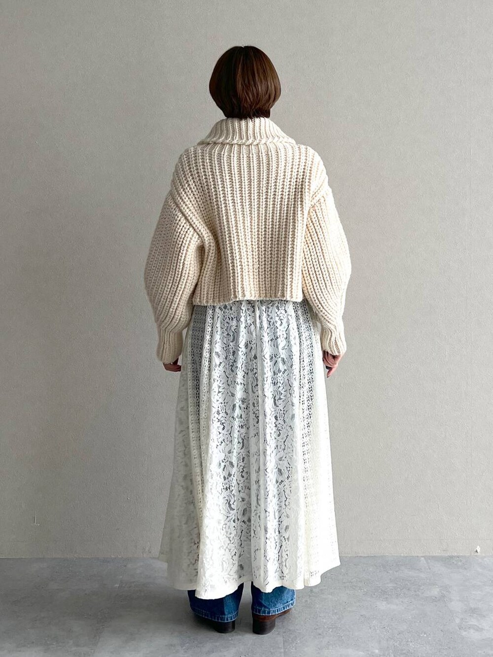 ホワイト系のワンピース、ブルー系のデニムパンツ、ブラウン系のローファーを着用したレディースの秋コーディネートの6枚目の写真