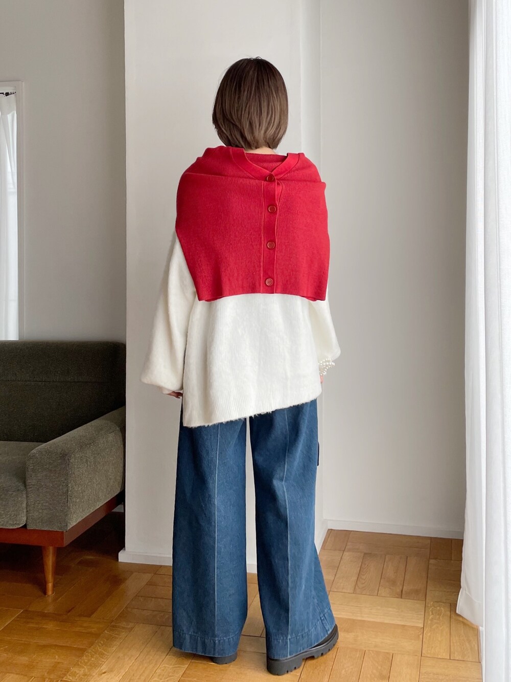 レッド系のカーディガン/ボレロ、ホワイト系のニット/セーター、ブルー系のデニムパンツを着用したレディースの冬コーディネートの3枚目の写真