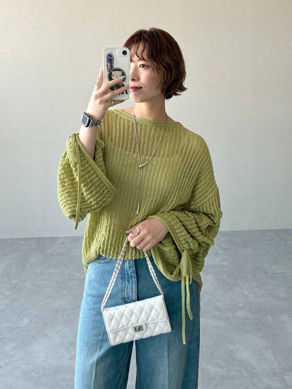 ブラック系のローファー、グリーン系のニット/セーター、ブルー系のデニムパンツを着用したレディースの冬コーディネートの4枚目の写真