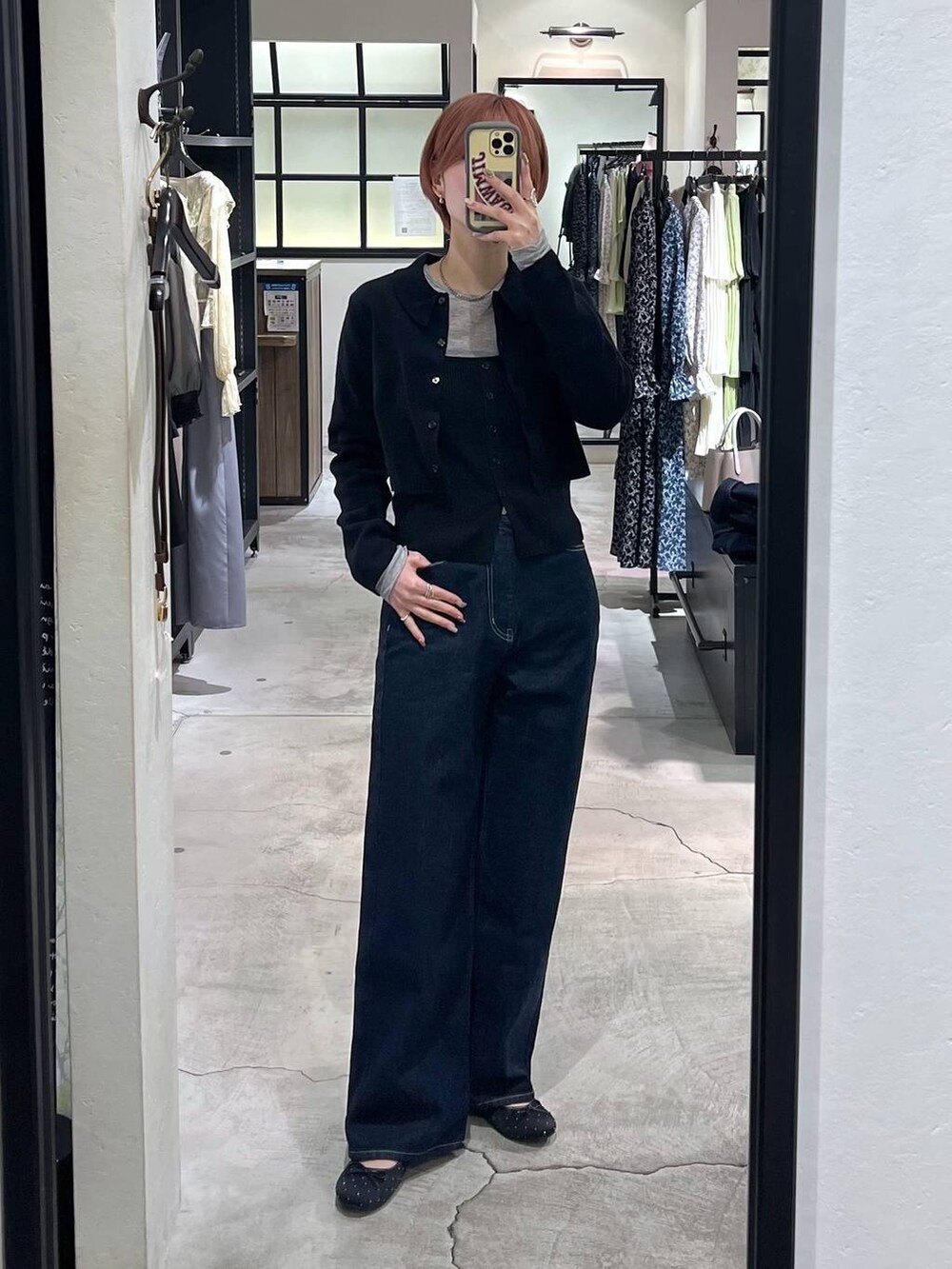 ブルー系のデニムパンツ、ベージュ系のショルダーバッグ、ブラック系のバレエシューズを着用したレディースの春コーディネートの4枚目の写真