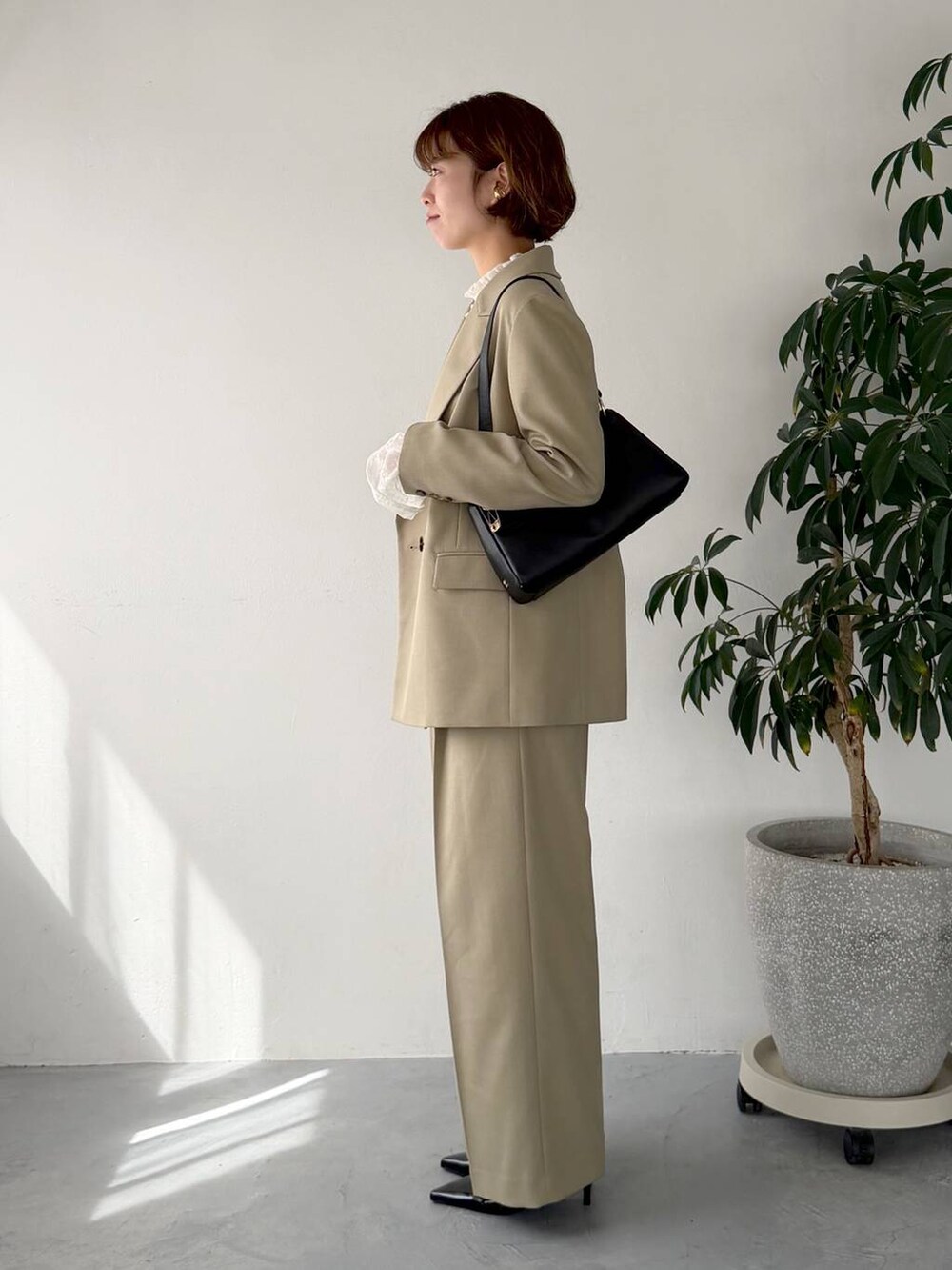 ベージュ系のテーラードジャケット、ベージュ系のその他パンツ、ブラック系のサンダルを着用したレディースの春コーディネートの2枚目の写真