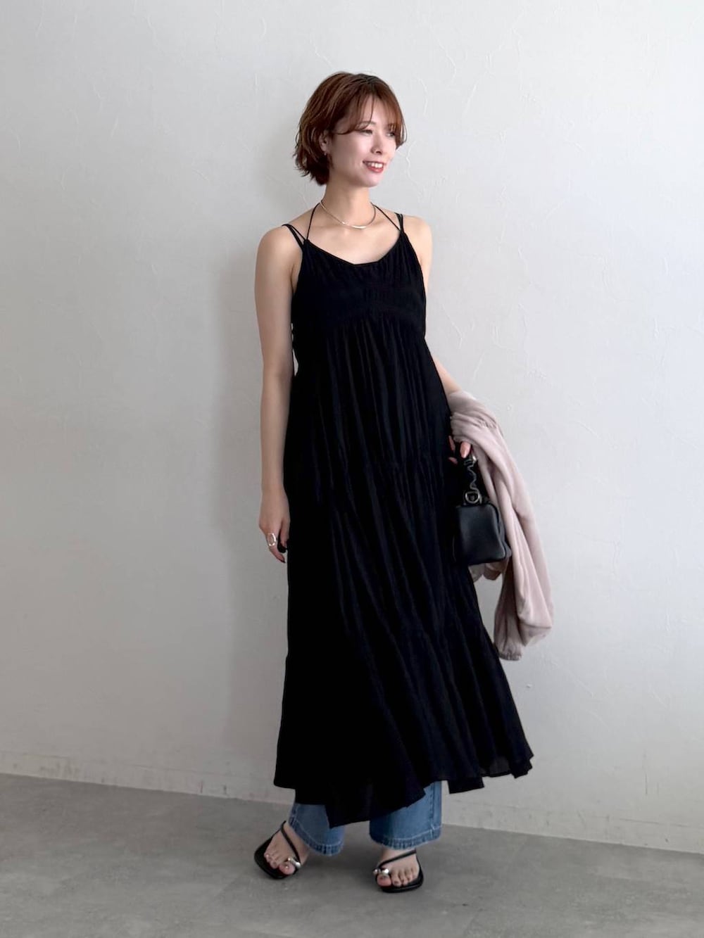ベージュ系のパーカー、ブルー系のデニムパンツ、ブラック系のショルダーバッグを着用したレディースの夏コーディネートの5枚目の写真