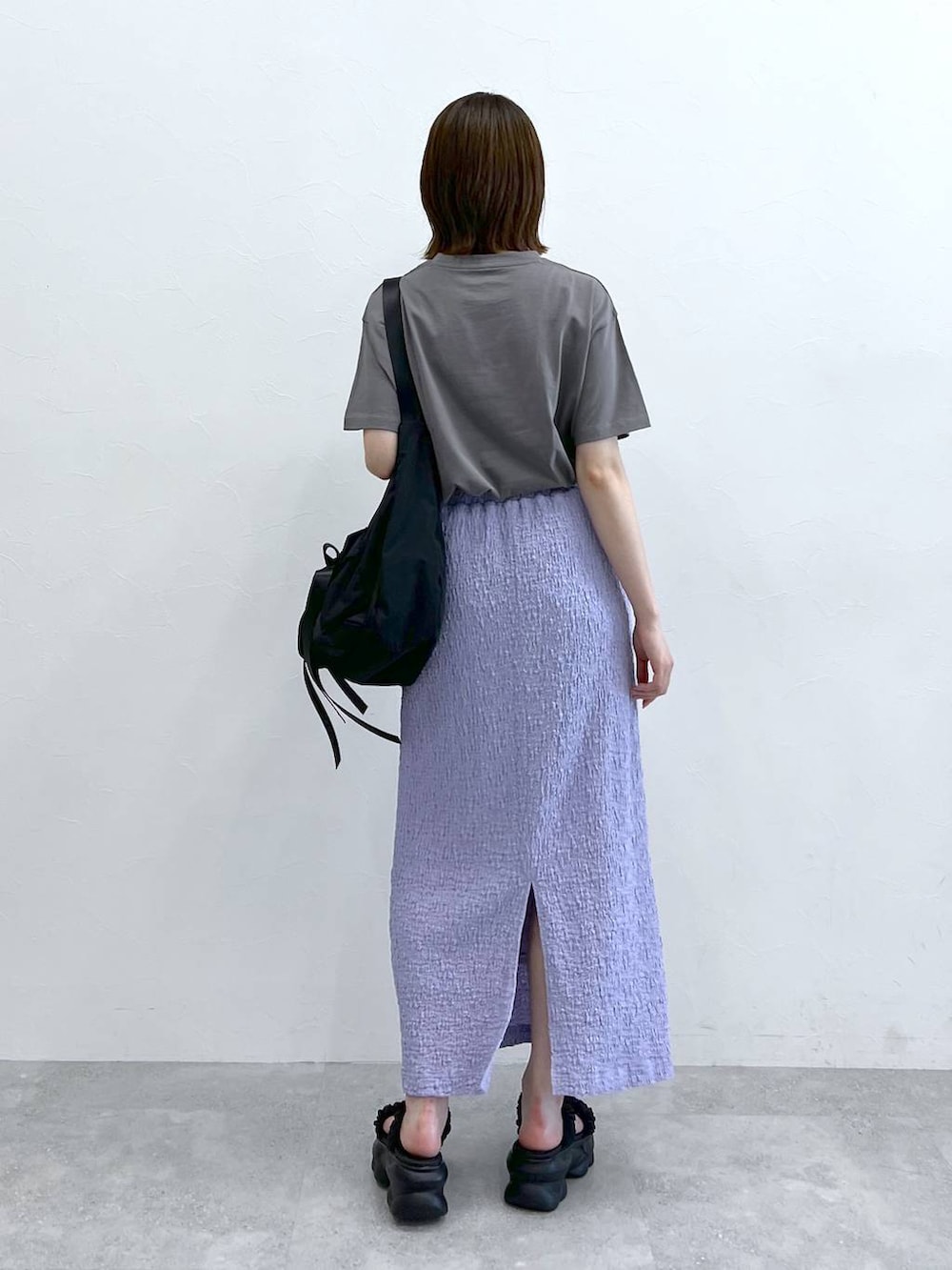 グレー系のTシャツ/カットソー、ブラック系のショルダーバッグ、ブラック系のサンダルを着用したレディースの春コーディネートの3枚目の写真