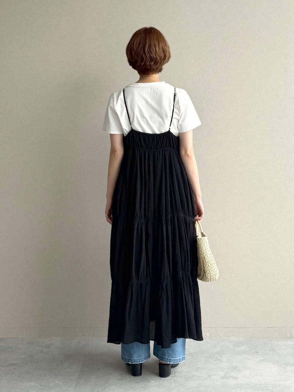ブルー系のデニムパンツ、ホワイト系のTシャツ/カットソー、ブラック系のワンピースを着用したレディースの夏コーディネートの3枚目の写真