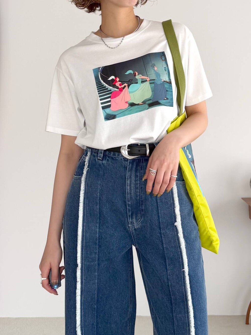 ブルー系のデニムパンツ、ブラック系のサンダル、ブラック系のベルトを着用したレディースの春コーディネートの4枚目の写真
