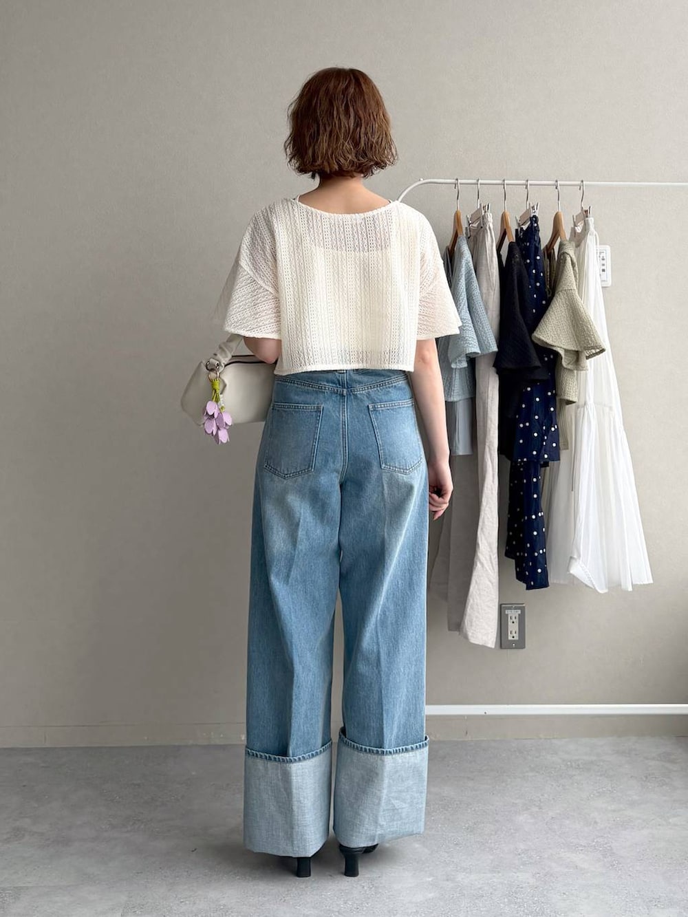 ホワイト系のカーディガン/ボレロ、ブルー系のデニムパンツ、ブラック系のサンダルを着用したレディースの春コーディネートの3枚目の写真