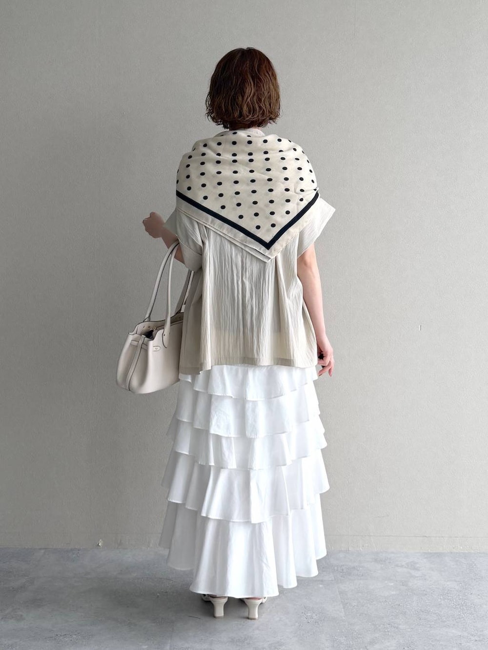 ホワイト系のサンダル、ブラウン系のTシャツ/カットソー、ホワイト系のスカートを着用したレディースの春コーディネートの3枚目の写真