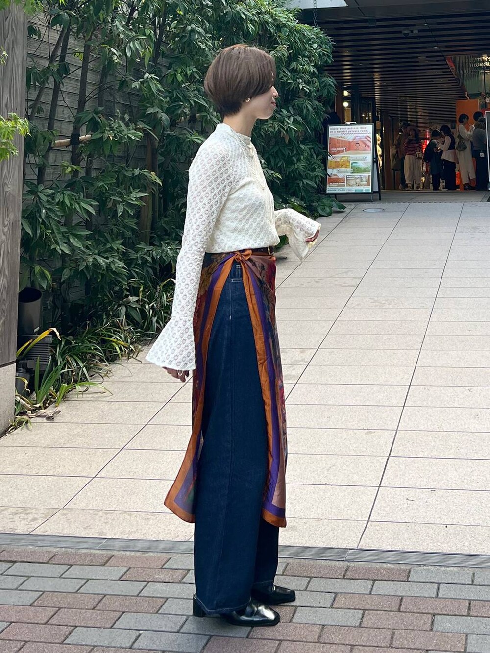 ブルー系のデニムパンツ、ブラック系のローファー、ホワイト系のTシャツ/カットソーを着用したレディースの秋コーディネートの2枚目の写真