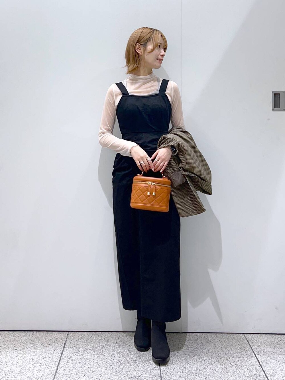 ブラック系のブーツ、ブラック系のジャンパースカート、ブラウン系のテーラードジャケットを着用したレディースの秋コーディネートの4枚目の写真