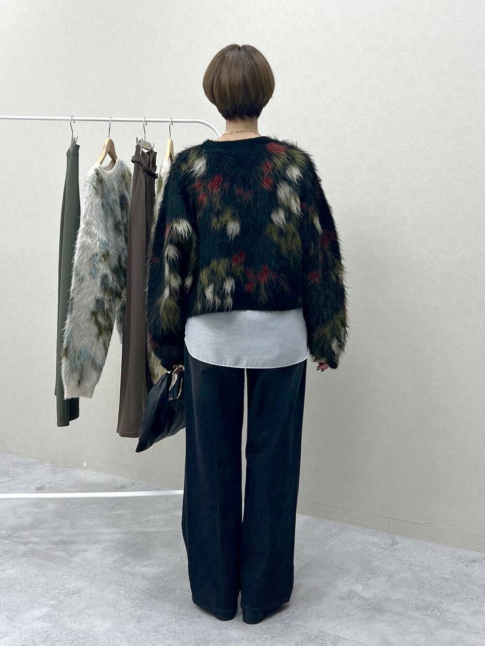 ブラック系のハンドバッグ、グレー系のデニムパンツ、ブラック系のローファーを着用したレディースの秋コーディネートの3枚目の写真