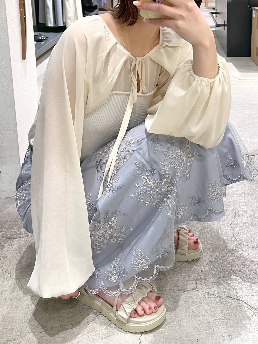 ブルー系のスカート、ホワイト系のTシャツ/カットソー、ホワイト系のサンダルを着用したレディースの春コーディネートの5枚目の写真