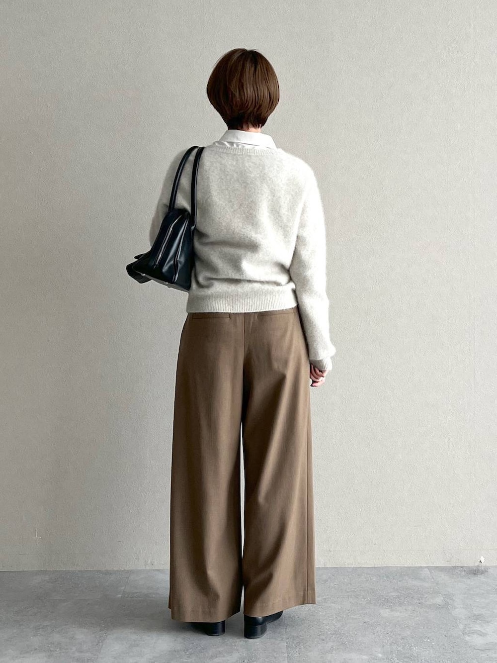 ブラック系のローファー、ブラック系のトートバッグ、ベージュ系のその他パンツを着用したレディースの秋コーディネートの3枚目の写真