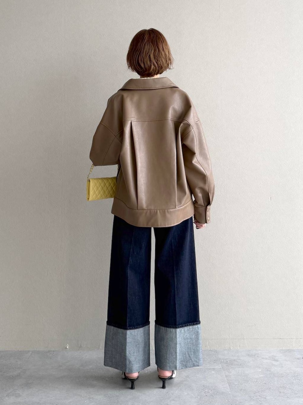 ホワイト系のサンダル、ブラウン系のブルゾン、イエロー系のカーディガン/ボレロを着用したレディースの春コーディネートの3枚目の写真