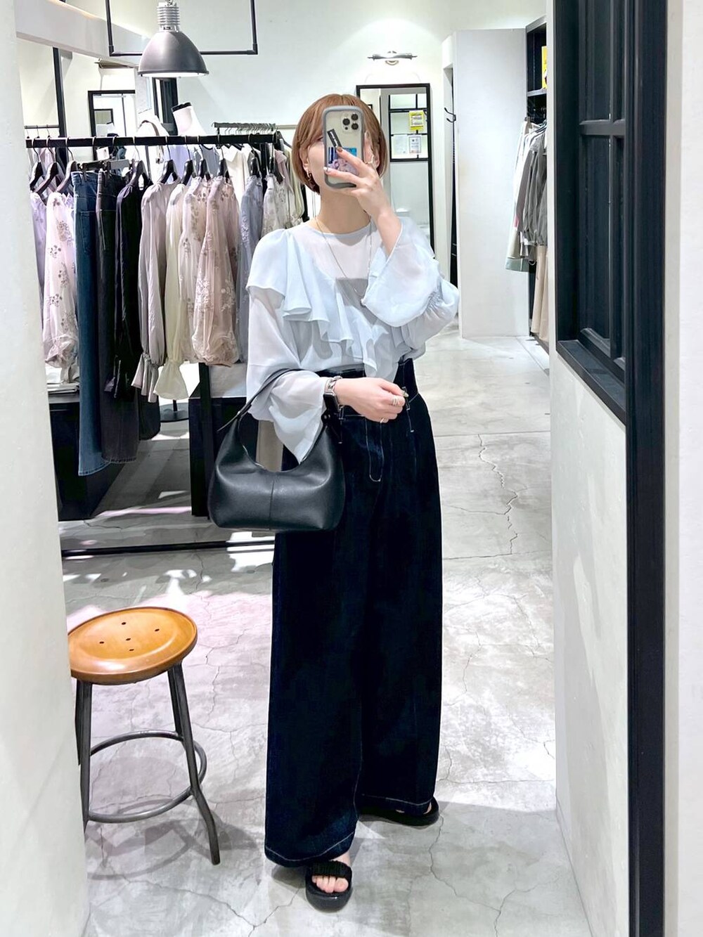 ブラック系のサンダル、ブルー系のデニムパンツ、ブラック系のショルダーバッグを着用したレディースの春コーディネートの4枚目の写真