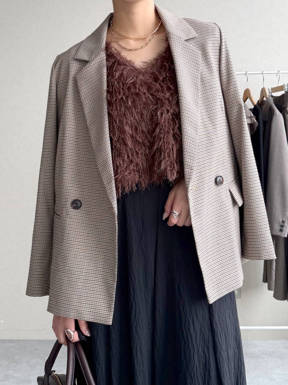 ブラウン系のベスト、ベージュ系のテーラードジャケット、ブラウン系のボストンバッグを着用したレディースの秋コーディネートの4枚目の写真