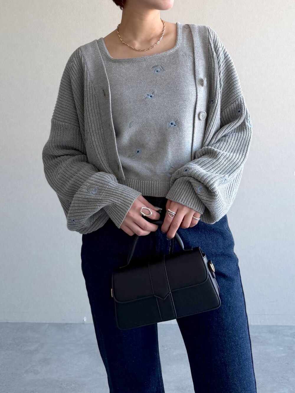 ブラック系のショルダーバッグ、ブルー系のデニムパンツ、ブラック系のサンダルを着用したレディースの冬コーディネートの4枚目の写真