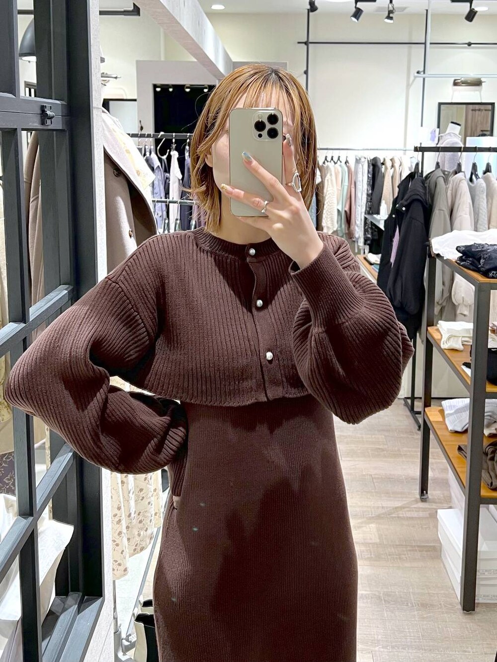 ブラック系のブーツ、ブラック系のハンドバッグ、ブラウン系のワンピースを着用したレディースの秋コーディネートの4枚目の写真