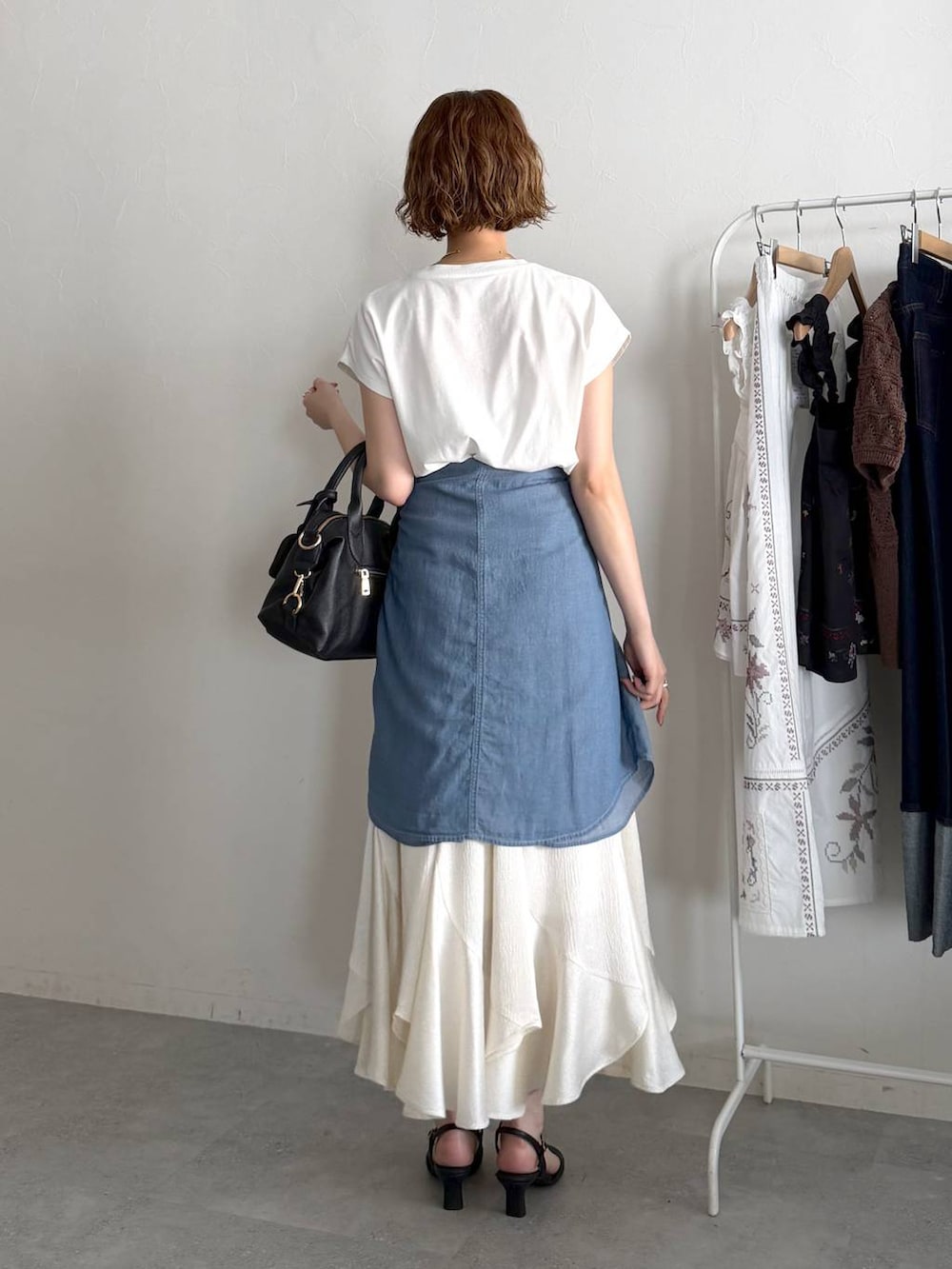 ブラック系のボストンバッグ、ブルー系のシャツ/ブラウス、ブラック系のサンダルを着用したレディースの春コーディネートの3枚目の写真