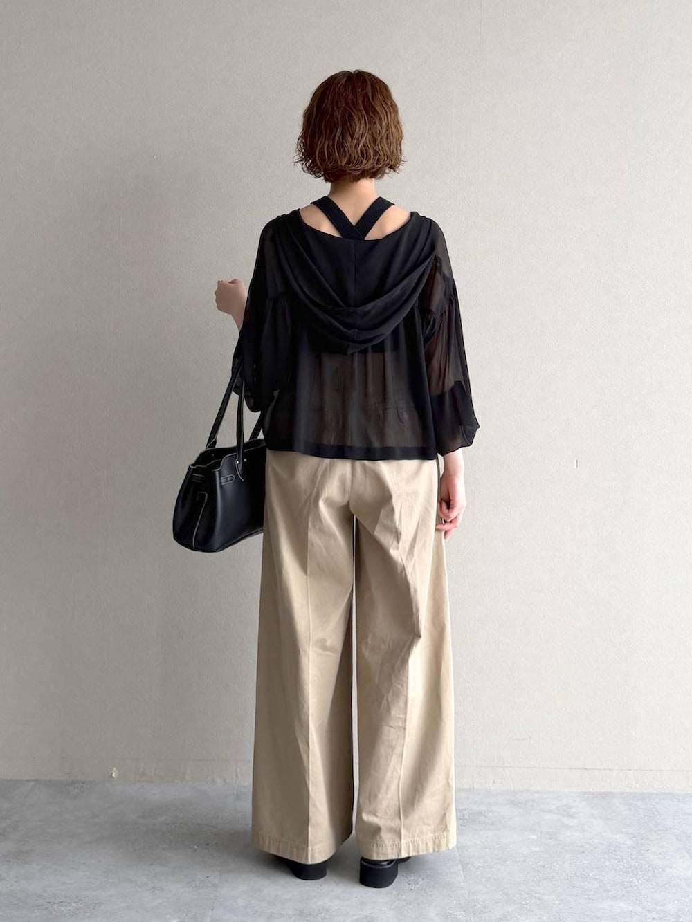 ブラック系のパーカー、ブラック系のサンダル、ブラック系のニット/セーターを着用したレディースの春コーディネートの3枚目の写真