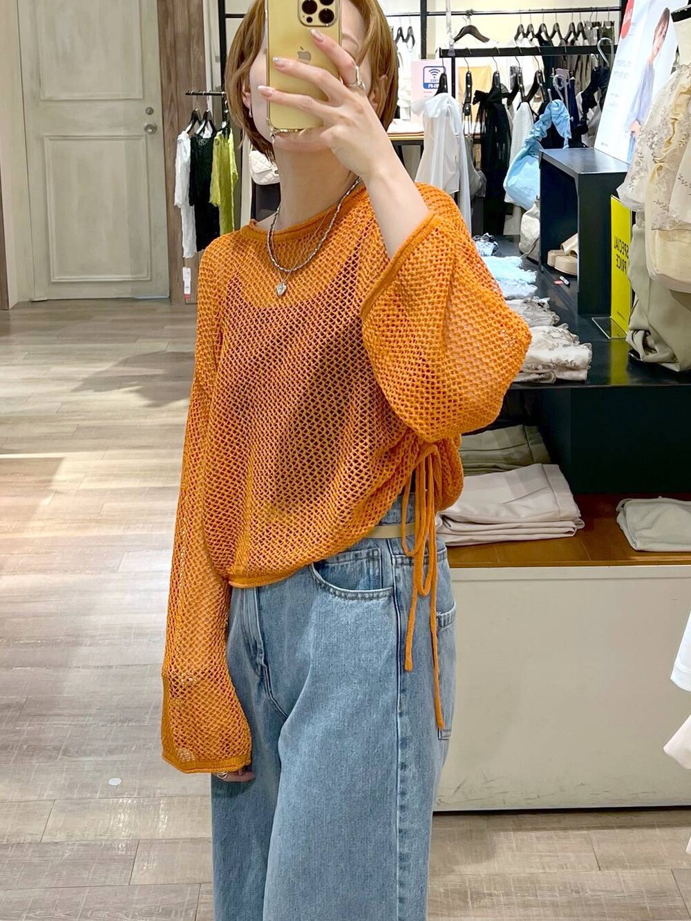 ブルー系のデニムパンツ、ブラック系のキャミソール、ブラック系のショルダーバッグを着用したレディースの夏コーディネートの4枚目の写真