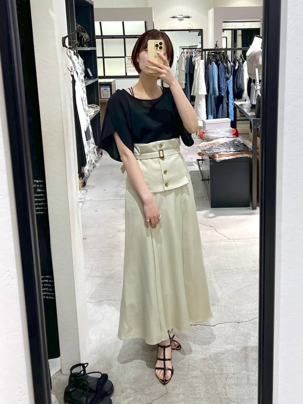 ホワイト系のスカート、ブラック系のショルダーバッグ、ブラック系のサンダルを着用したレディースの夏コーディネートの5枚目の写真