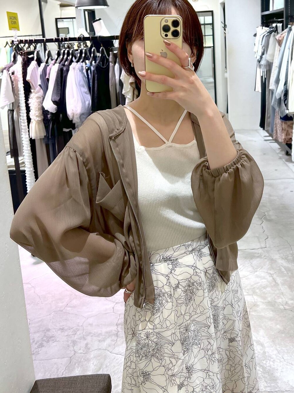 ホワイト系のサンダル、ホワイト系のショルダーバッグ、ブラウン系のパーカーを着用したレディースの夏コーディネートの4枚目の写真