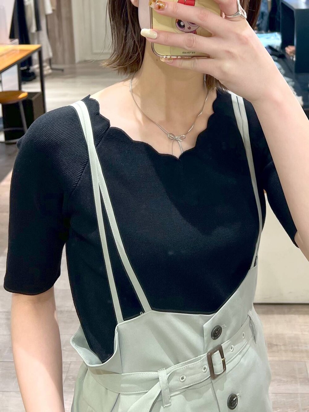 グリーン系のスカート、ブラック系のニット/セーター、ブラック系のサンダルを着用したレディースの春コーディネートの5枚目の写真