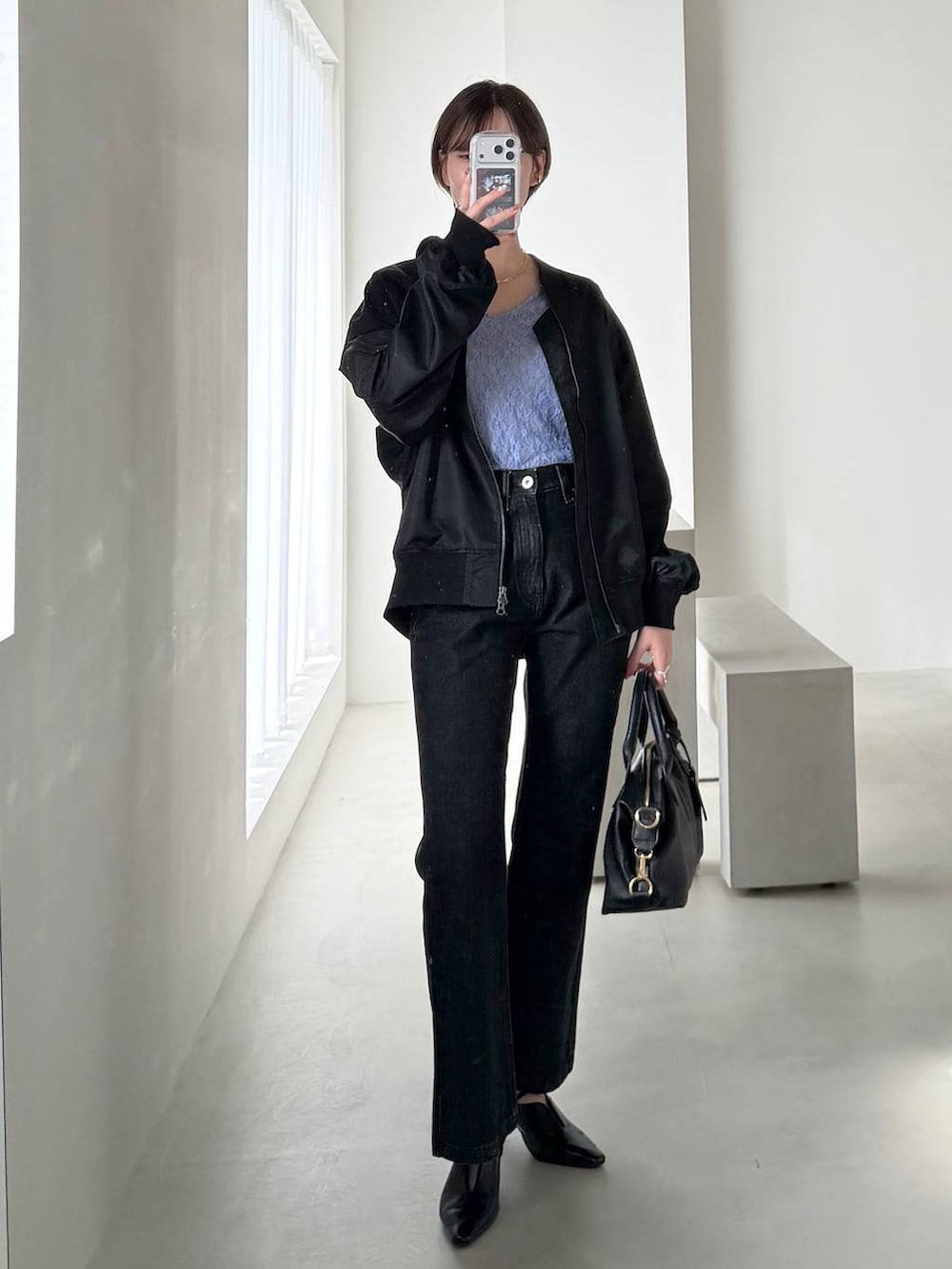 ブラック系のボストンバッグ、ブラック系のデニムパンツ、ブラック系のサンダルを着用したレディースの冬コーディネートの8枚目の写真