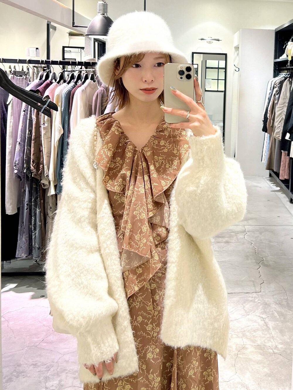 ホワイト系のショルダーバッグ、ホワイト系のカーディガン/ボレロ、ブラウン系のブーツを着用したレディースの秋コーディネートの5枚目の写真