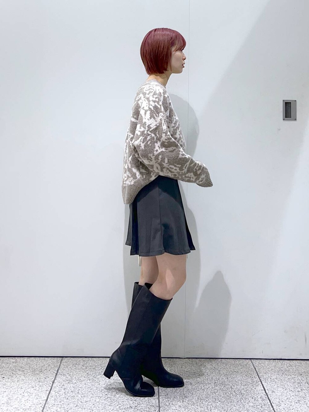 ブラック系のブルゾン、ホワイト系のボストンバッグ、ブラック系のブーツを着用したレディースの秋コーディネートの5枚目の写真