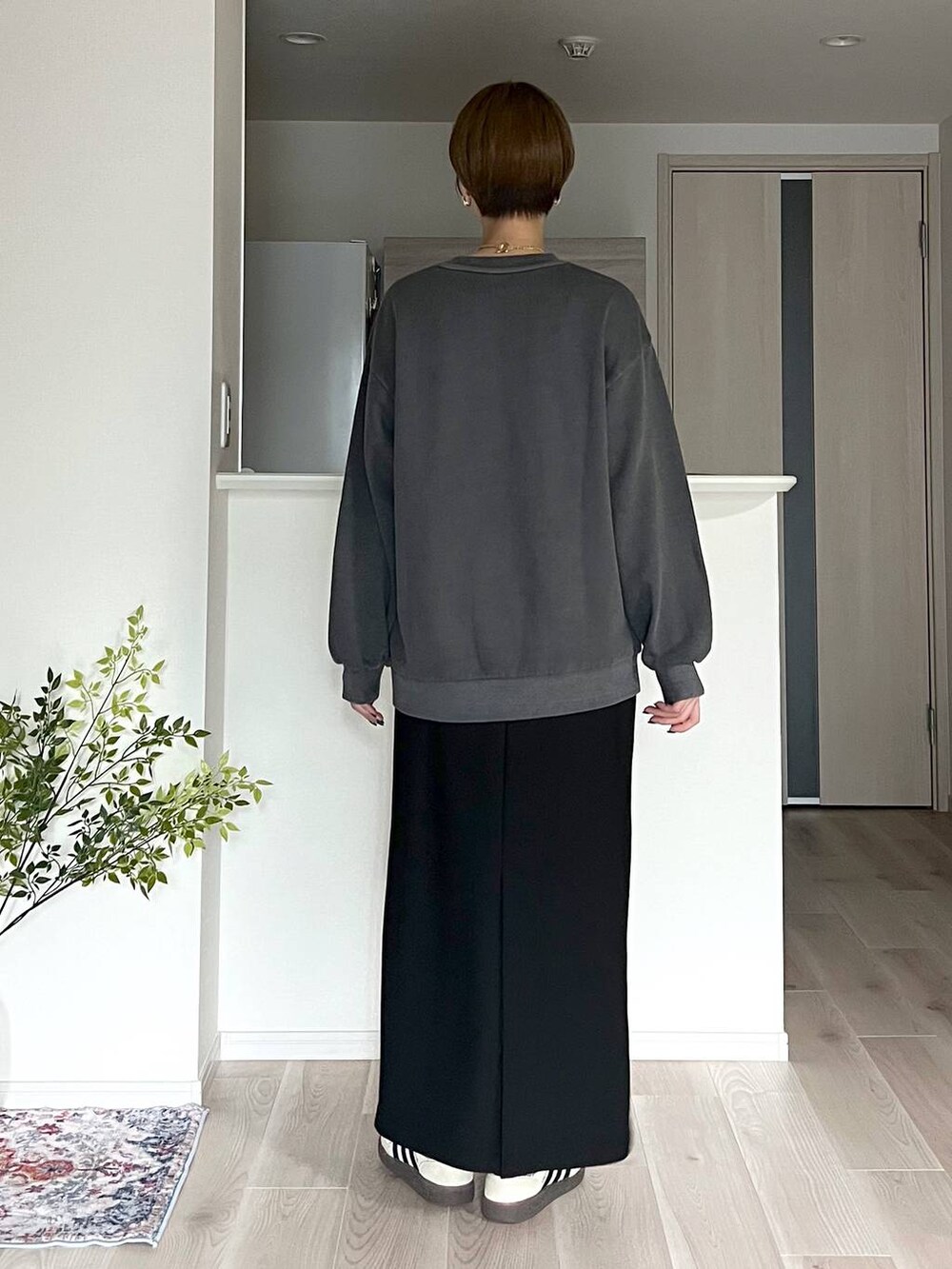 ブラウン系のボストンバッグ、ブラック系のスカート、ベージュ系のネックレスを着用したレディースの秋コーディネートの7枚目の写真