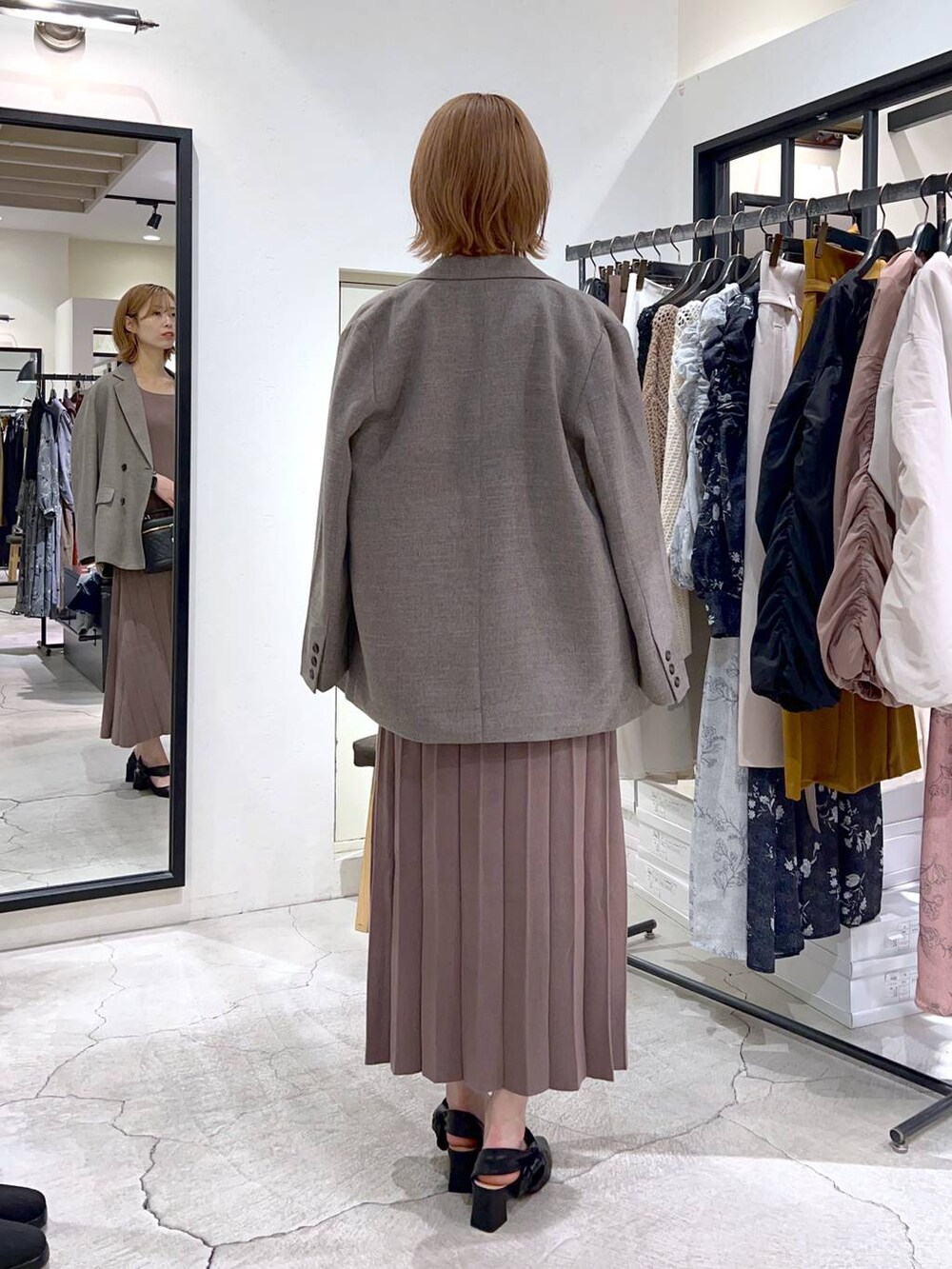 ブラック系のパンプス、グレー系のテーラードジャケット、ブラウン系のワンピースを着用したレディースの秋コーディネートの2枚目の写真