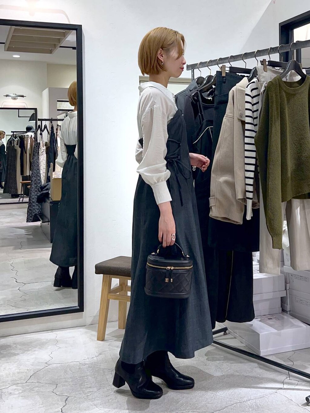 ブラック系のブーツ、グレー系のワンピース、ブラック系のショルダーバッグを着用したレディースの秋コーディネートの2枚目の写真