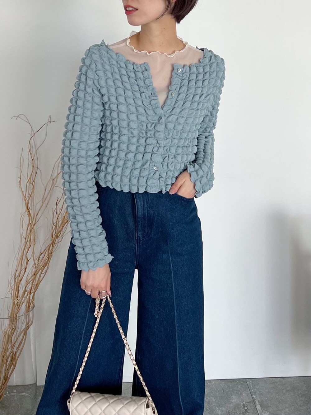 ブルー系のカーディガン/ボレロ、ホワイト系のトップス、ホワイト系のバッグを着用したレディースの夏コーディネートの4枚目の写真