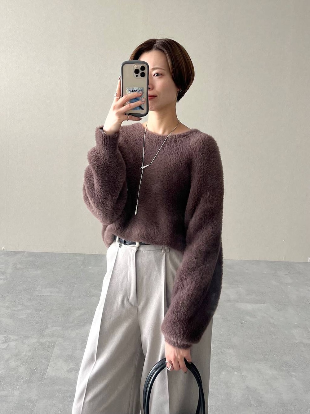 ブラック系のローファー、ブラック系のトートバッグ、ブラウン系のニット/セーターを着用したレディースの秋コーディネートの5枚目の写真