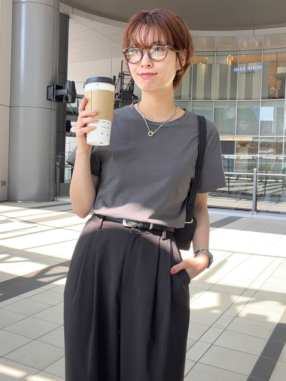 グレー系のTシャツ/カットソー、ブラック系のショルダーバッグ、ブラウン系のサングラスを着用したレディースの夏コーディネートの4枚目の写真