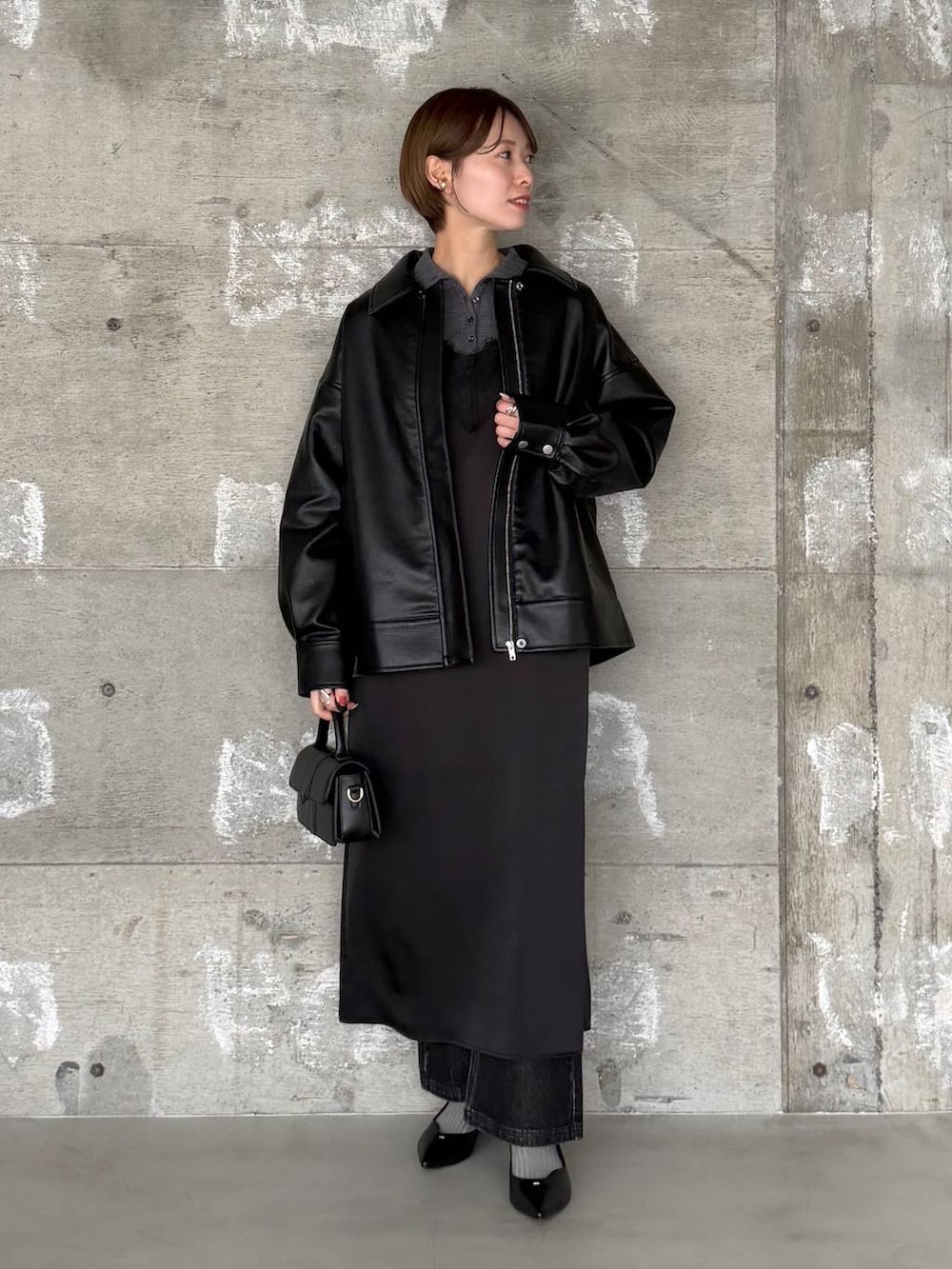 ブラック系のショルダーバッグ、ブラック系のデニムパンツ、ブラック系のパンプスを着用したレディースの冬コーディネートの2枚目の写真