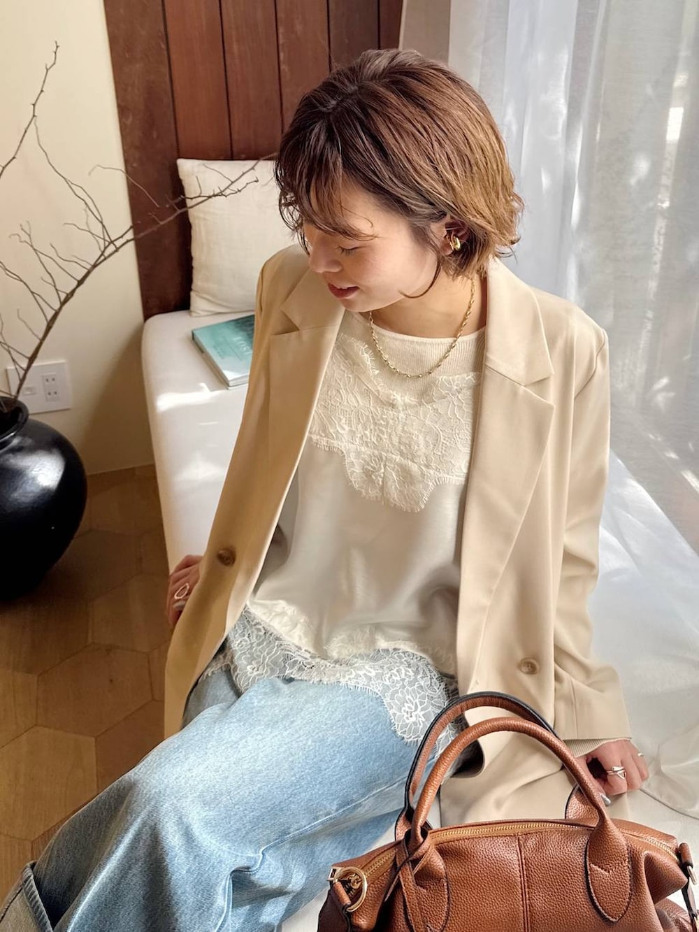 ブラウン系のボストンバッグ、ブルー系のパンプス、ホワイト系のキャミソールを着用したレディースの冬コーディネートの4枚目の写真