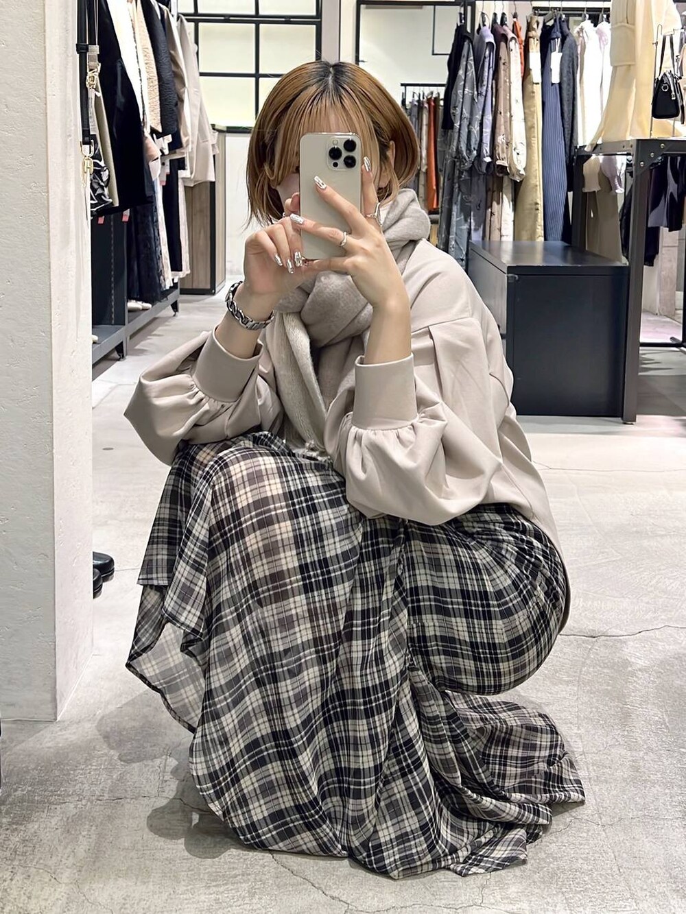 ホワイト系のボストンバッグ、ベージュ系のTシャツ/カットソー、ブラック系のブーツを着用したレディースの秋コーディネートの5枚目の写真