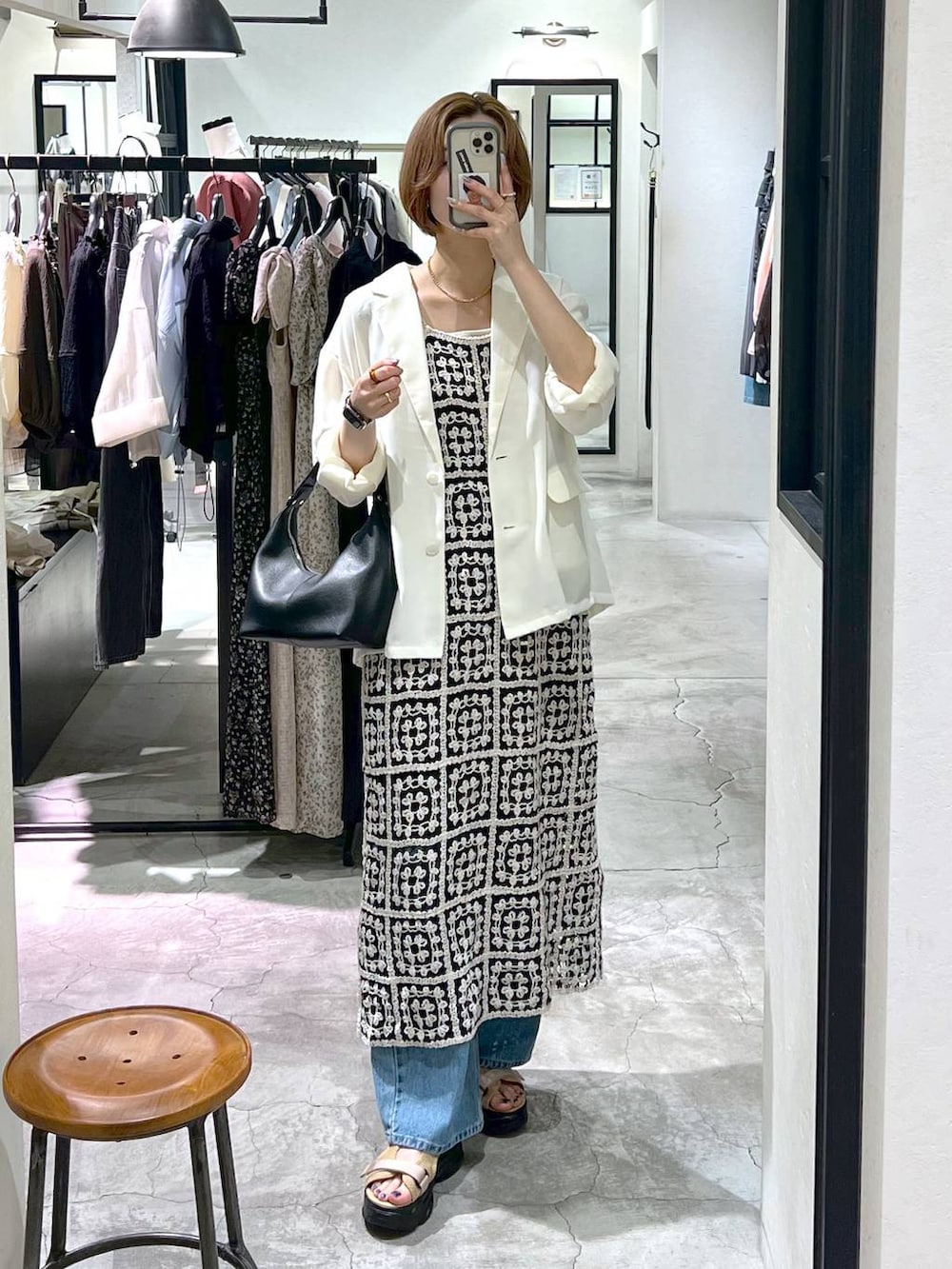 ブルー系のデニムパンツ、ベージュ系のサンダル、ブラック系のショルダーバッグを着用したレディースの夏コーディネートの4枚目の写真