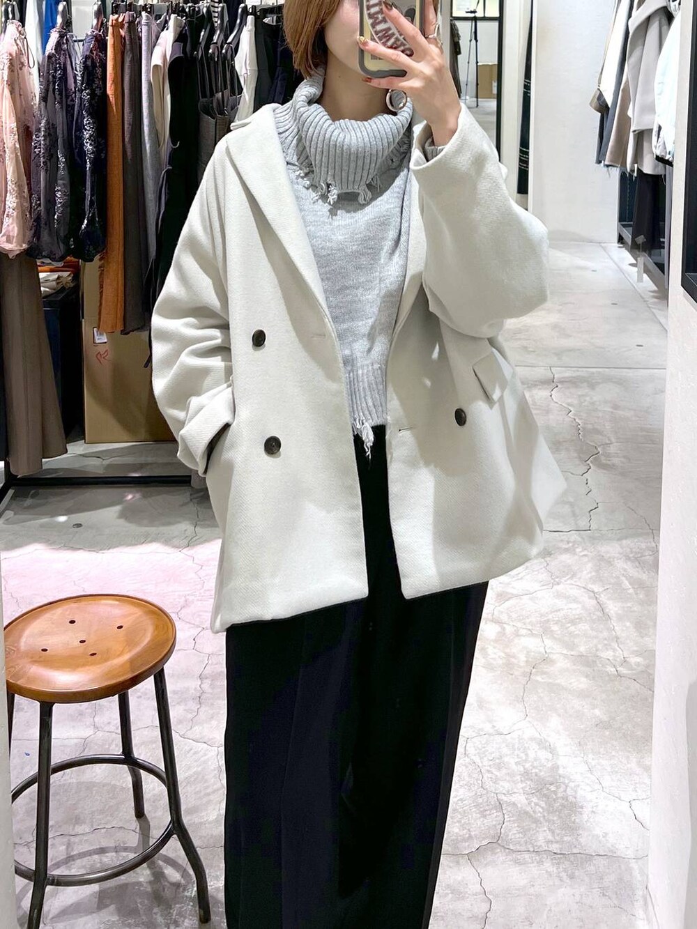 ブラック系のブーツ、ブラック系のショルダーバッグ、ホワイト系のその他アウターを着用したレディースの秋コーディネートの7枚目の写真