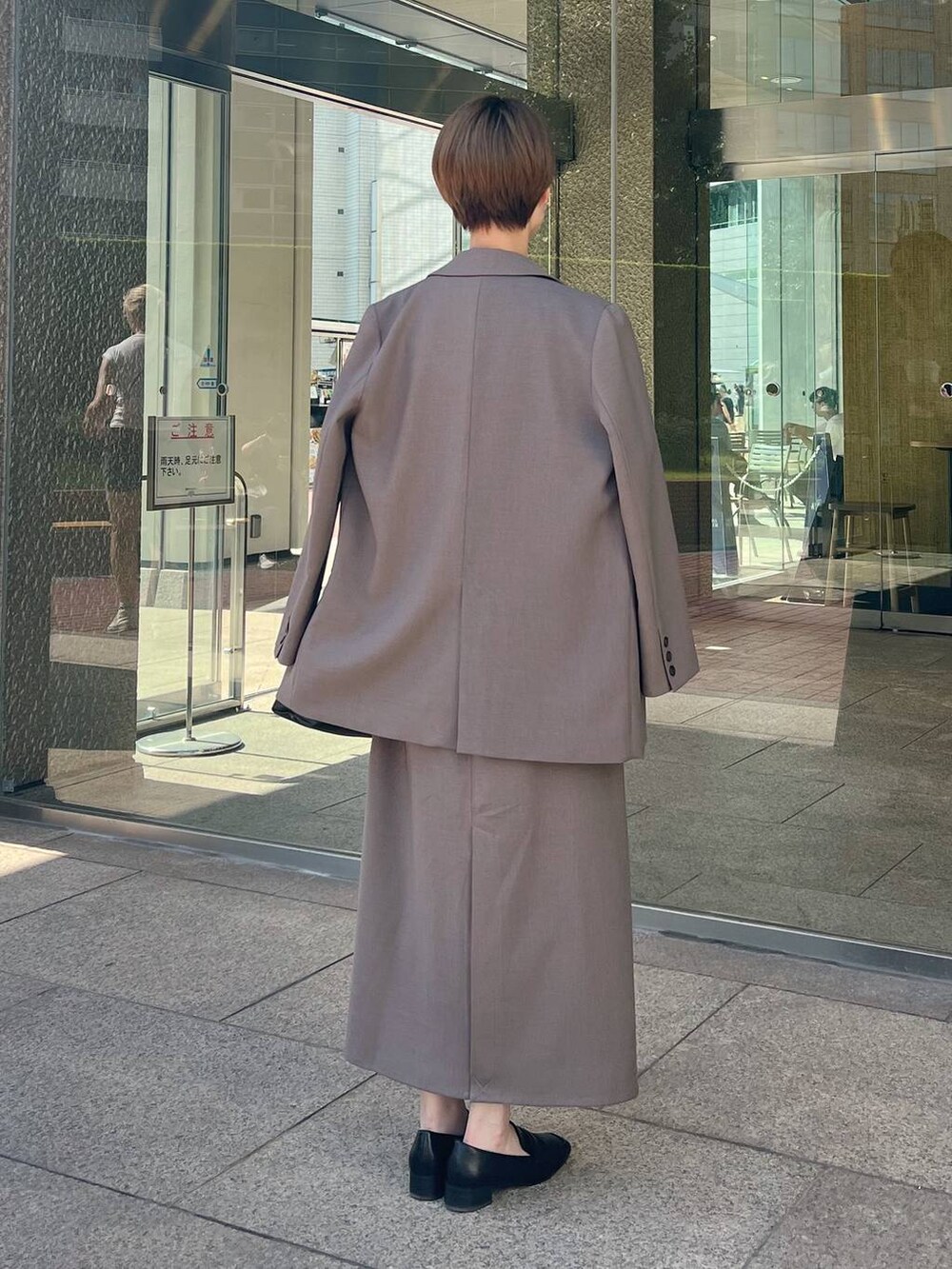 ホワイト系のTシャツ/カットソー、ブラック系のローファー、ベージュ系のワンピースを着用したレディースの秋コーディネートの3枚目の写真