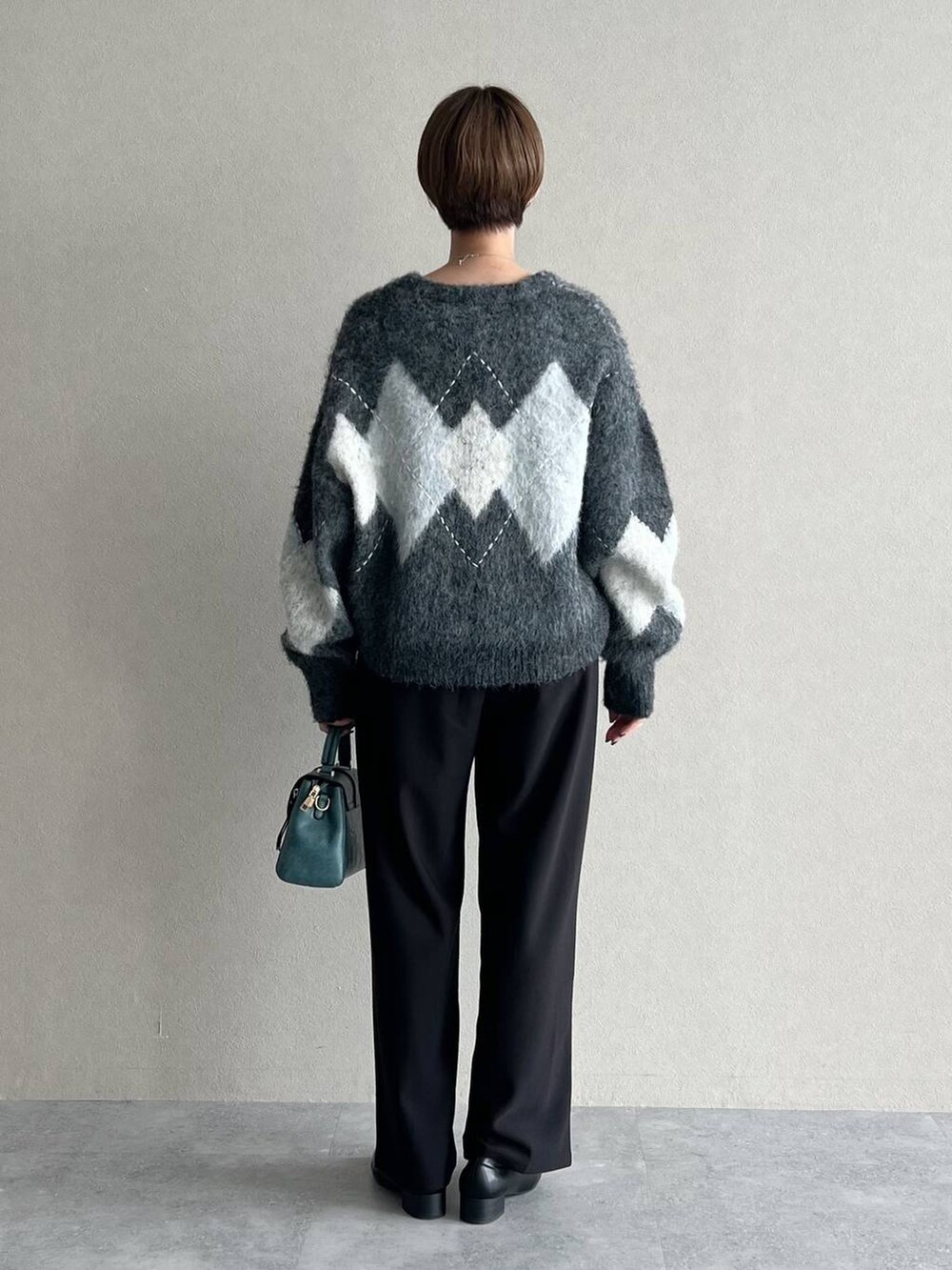 グレー系のカーディガン/ボレロ、ホワイト系のTシャツ/カットソー、ブラック系のローファーを着用したレディースの秋コーディネートの3枚目の写真