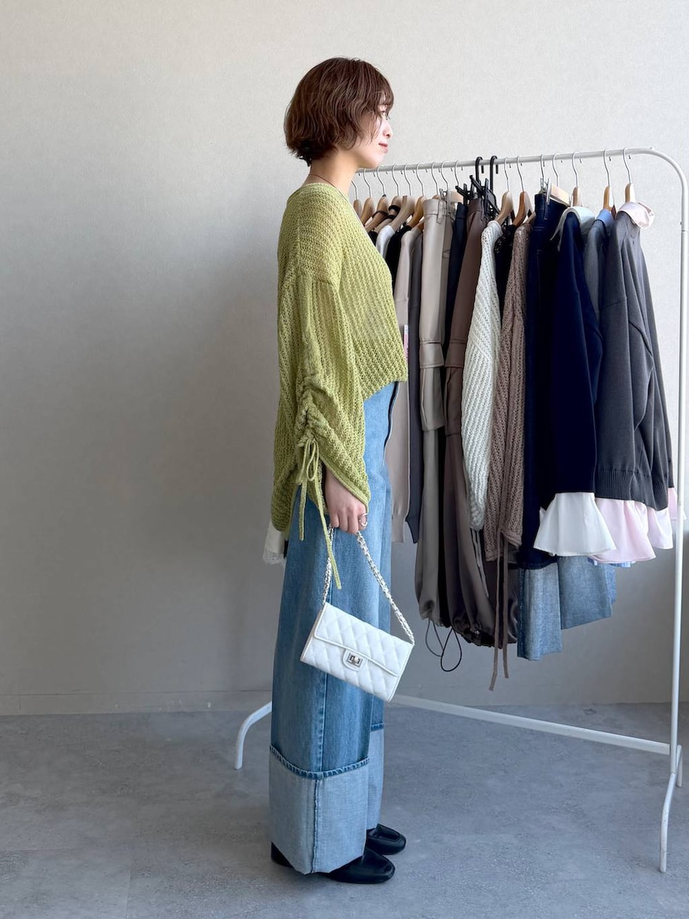 ブラック系のローファー、グリーン系のニット/セーター、ブルー系のデニムパンツを着用したレディースの冬コーディネートの2枚目の写真