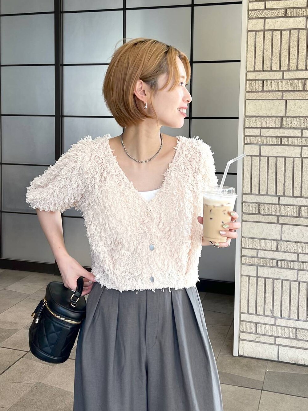 ホワイト系のカーディガン/ボレロ、ブラック系のショルダーバッグ、グレー系のその他パンツを着用したレディースの秋コーディネートの4枚目の写真