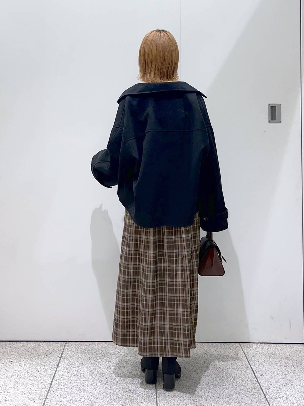 ブラック系のその他アウター、ブラウン系のハンドバッグ、ブラック系のブーツを着用したレディースの秋コーディネートの3枚目の写真