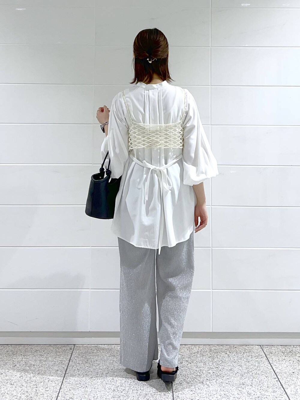 ホワイト系のシャツ/ブラウス、ホワイト系のベスト、ブラック系のサンダルを着用したレディースの春コーディネートの4枚目の写真