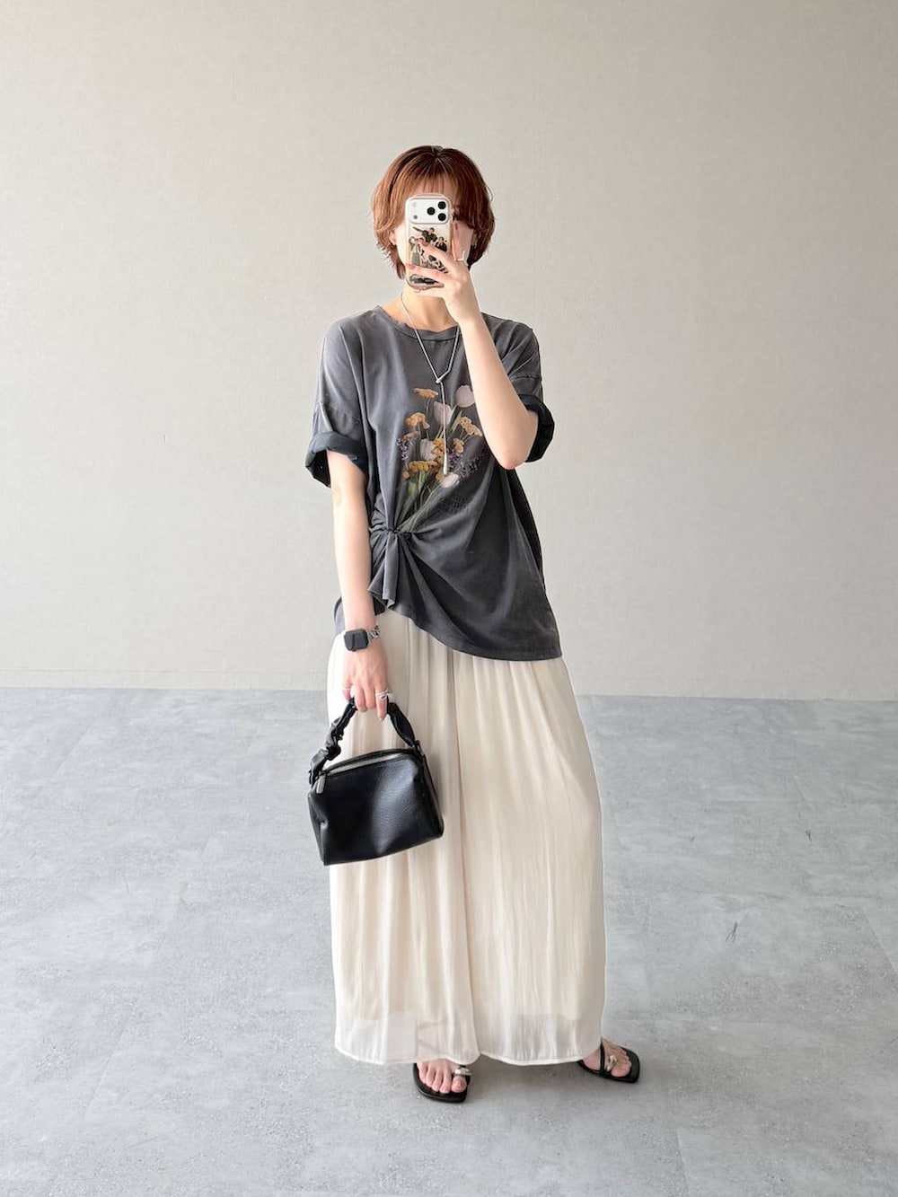 ブラック系のショルダーバッグ、グレー系のTシャツ/カットソー、ブラック系のサンダルを着用したレディースの夏コーディネートの5枚目の写真