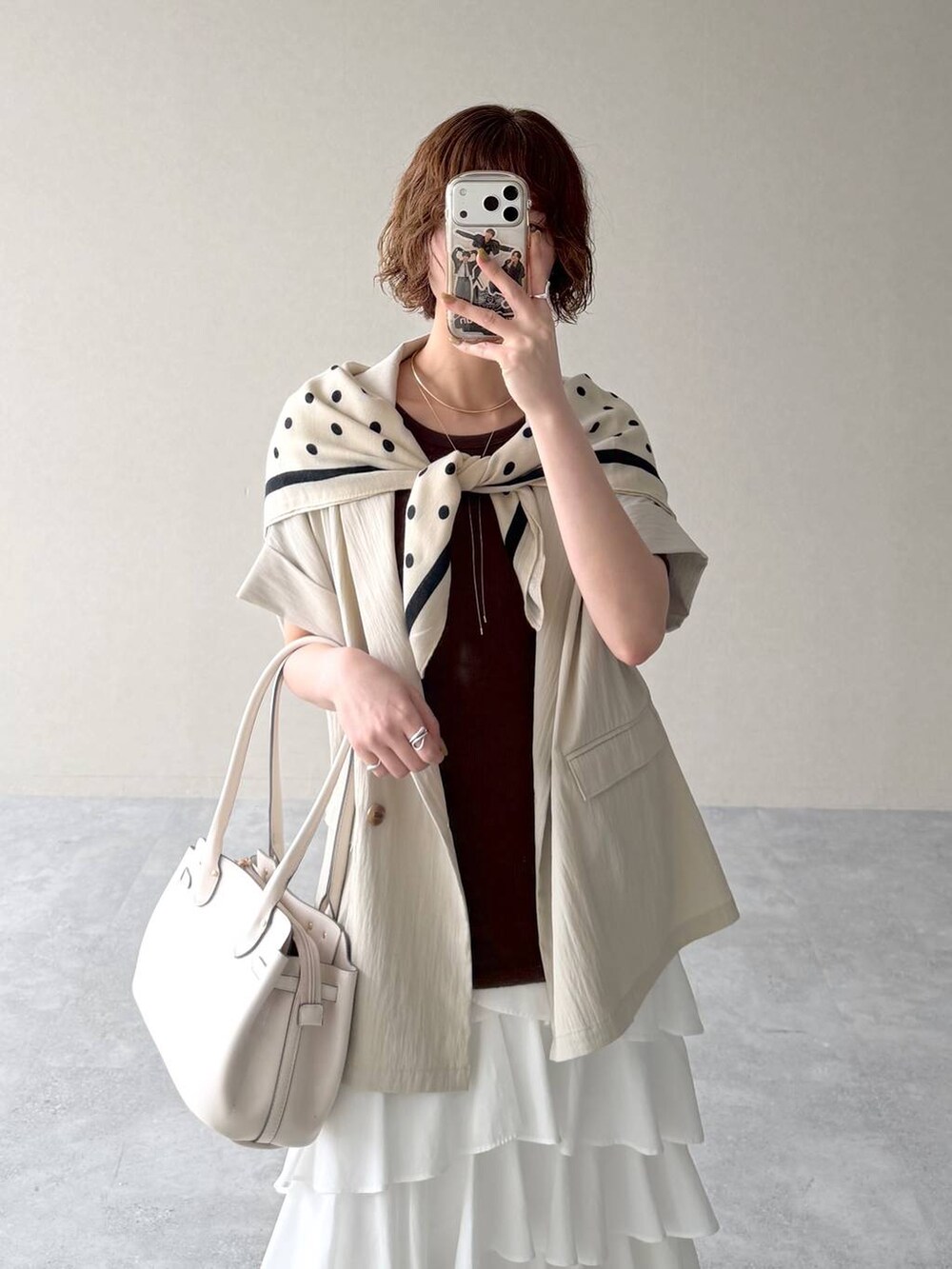 ホワイト系のサンダル、ブラウン系のTシャツ/カットソー、ホワイト系のスカートを着用したレディースの春コーディネートの6枚目の写真