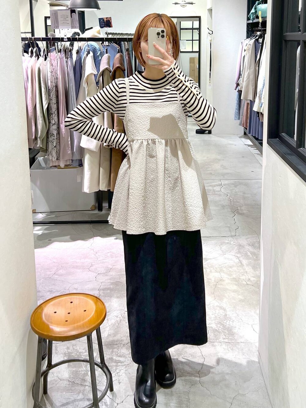 ブラック系のスカート、ベージュ系のキャミソール、ブラック系のハンドバッグを着用したレディースの冬コーディネートの4枚目の写真